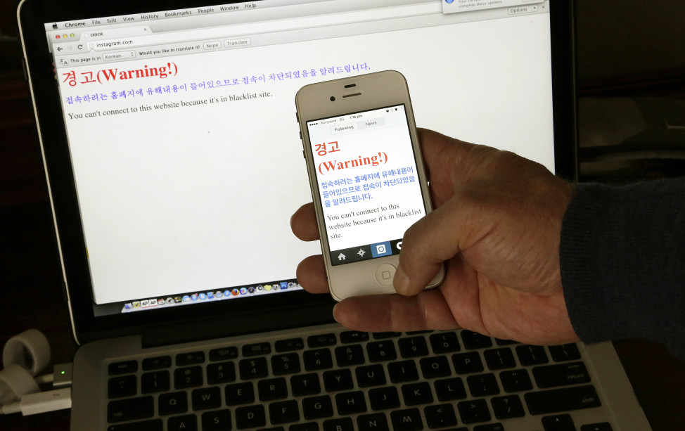 FILE - A notification saying, "Warning! You can't connect to this website because it's in blacklist site" is seen on both a computer screen and on a smartphone screen in Pyongyang, North Korea, June 20, 2015. (AP)