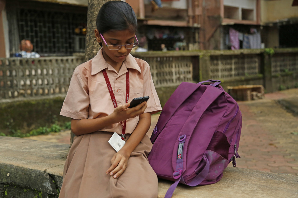 Amisha Vittal Khedekar, a student reading outside her school in India. (Worldreader)