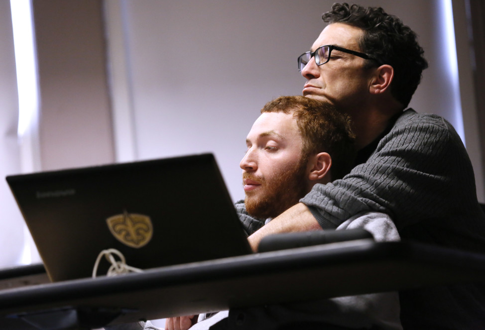 Sam Alexander holds his son Ben, who has autism, during a class for screenwriting at Tulane University in New Orleans, March 2, 2016. Ben's father sometimes places his hand over Ben's mouth to quiet him, or nudges him to participate in a discussion. (AP)