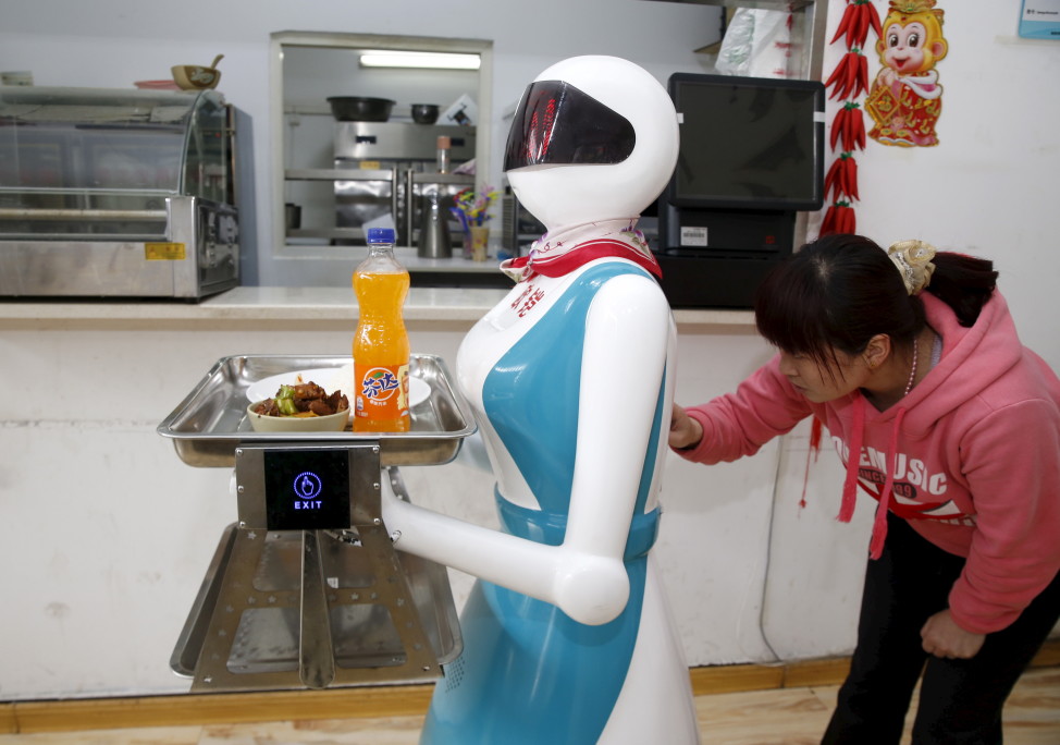 A woman inputs orders for a robot which works as a waitress in a restaurant in Xi'an, Shaanxi Province, China, April 20, 2016. (Reuters/China Stringer network)