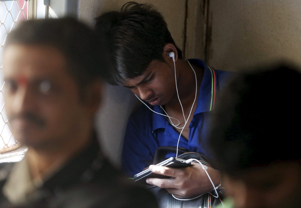 FILE - A man watches a video on his mobile phone as he commutes by a suburban train in Mumbai, India, March 31, 2016. (Reuters)