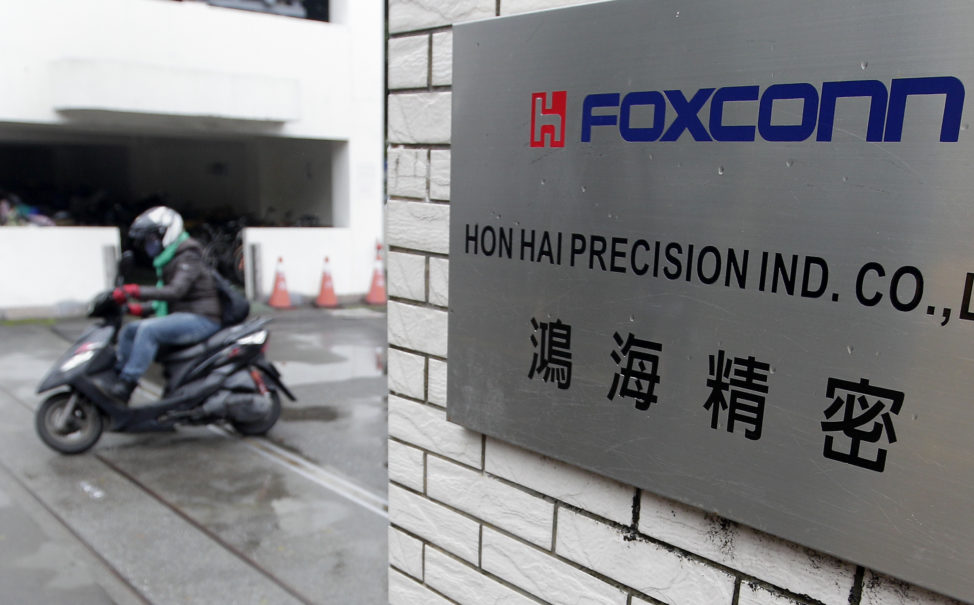 A motorcyclist rides past the entrance of the headquarters of Foxconn, in Tucheng, New Taipei city. Taiwan. (Reuters)