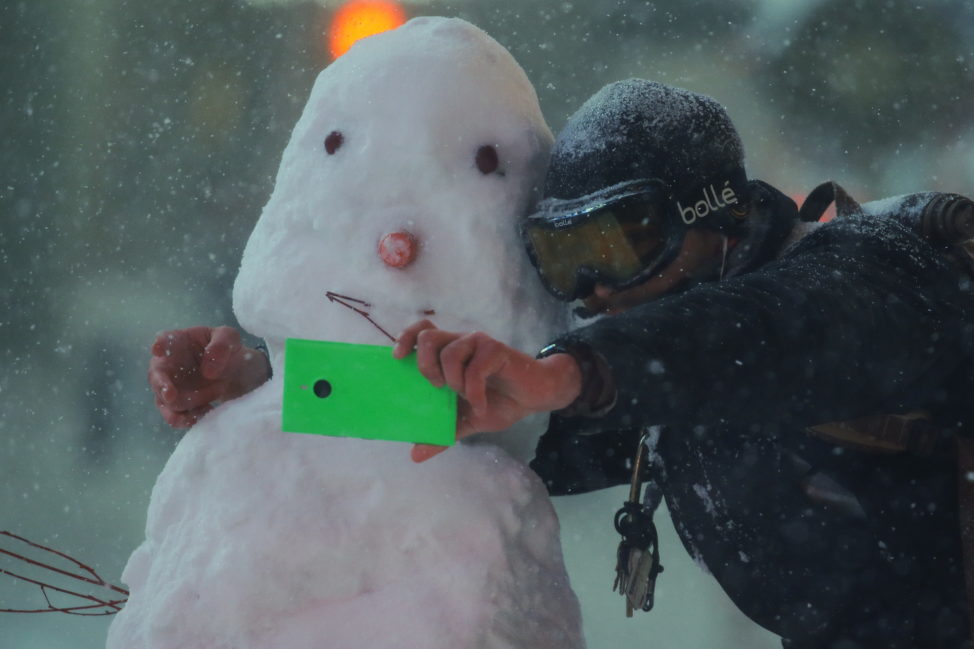 A man takes a selfie with a snowman during a snow storm in Times Square in the Manhattan borough of New York, Jan. 23, 2016. (Reuters)