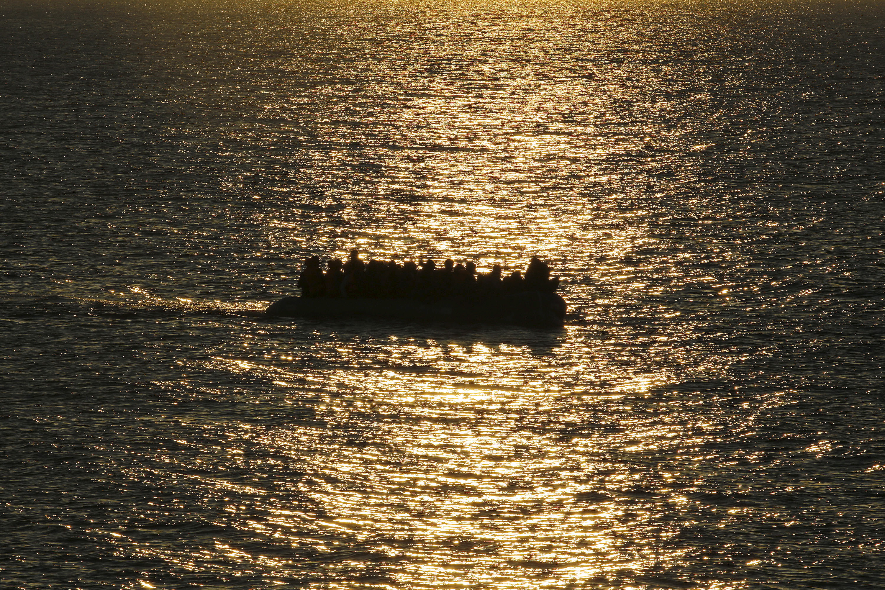 FILE - A raft overcrowded with migrants and refugees approaches a beach at dawn on the Greek island of Lesbos Nov. 17, 2015. (Reuters)