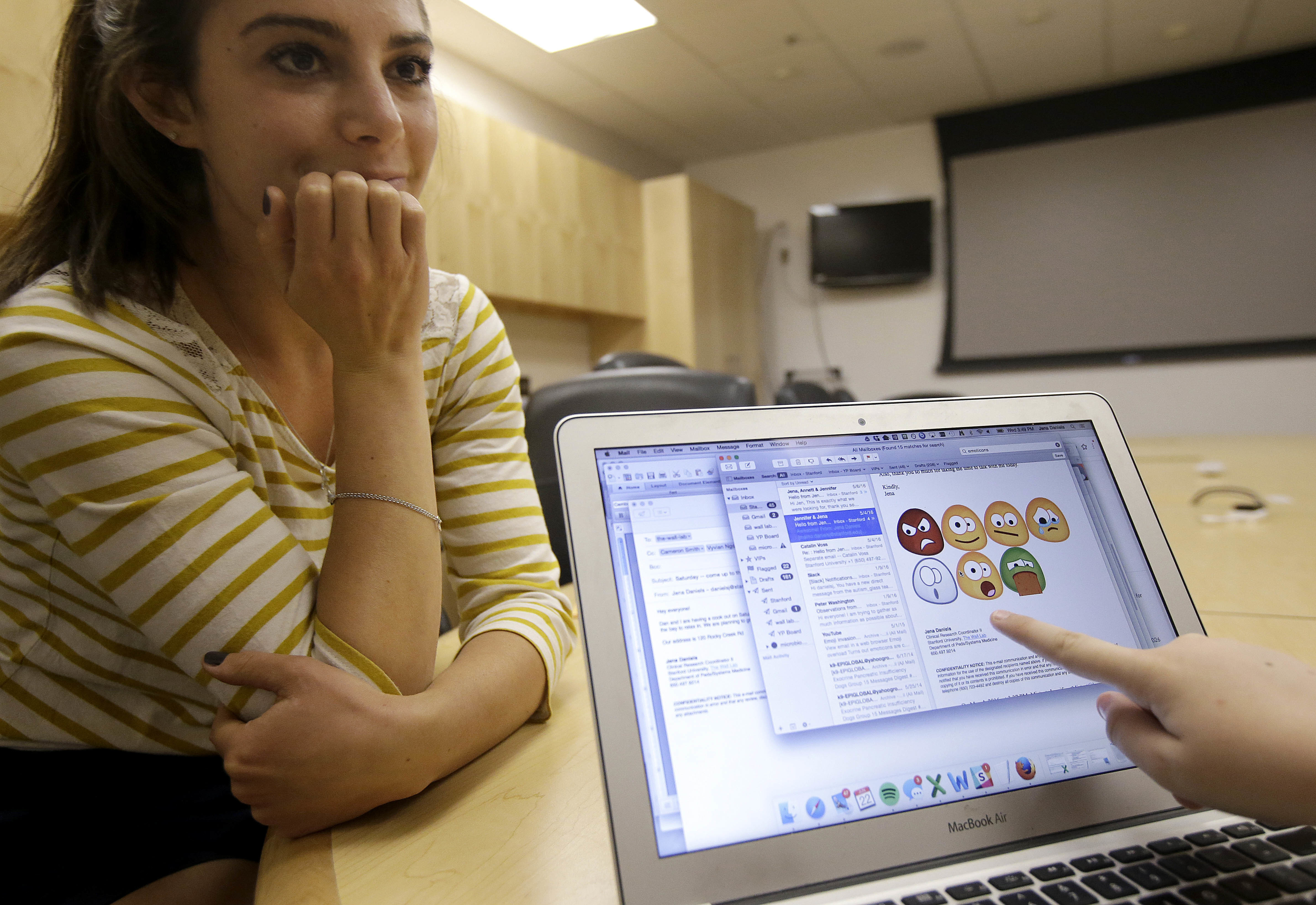 Jena Daniels, clinical research coordinator at The Wall Lab (L) watches Julian Brown point to images, used in an emotion recognition exercise, that would appear on Google Glass glasses in Stanford, California, June 22, 2016. (AP)