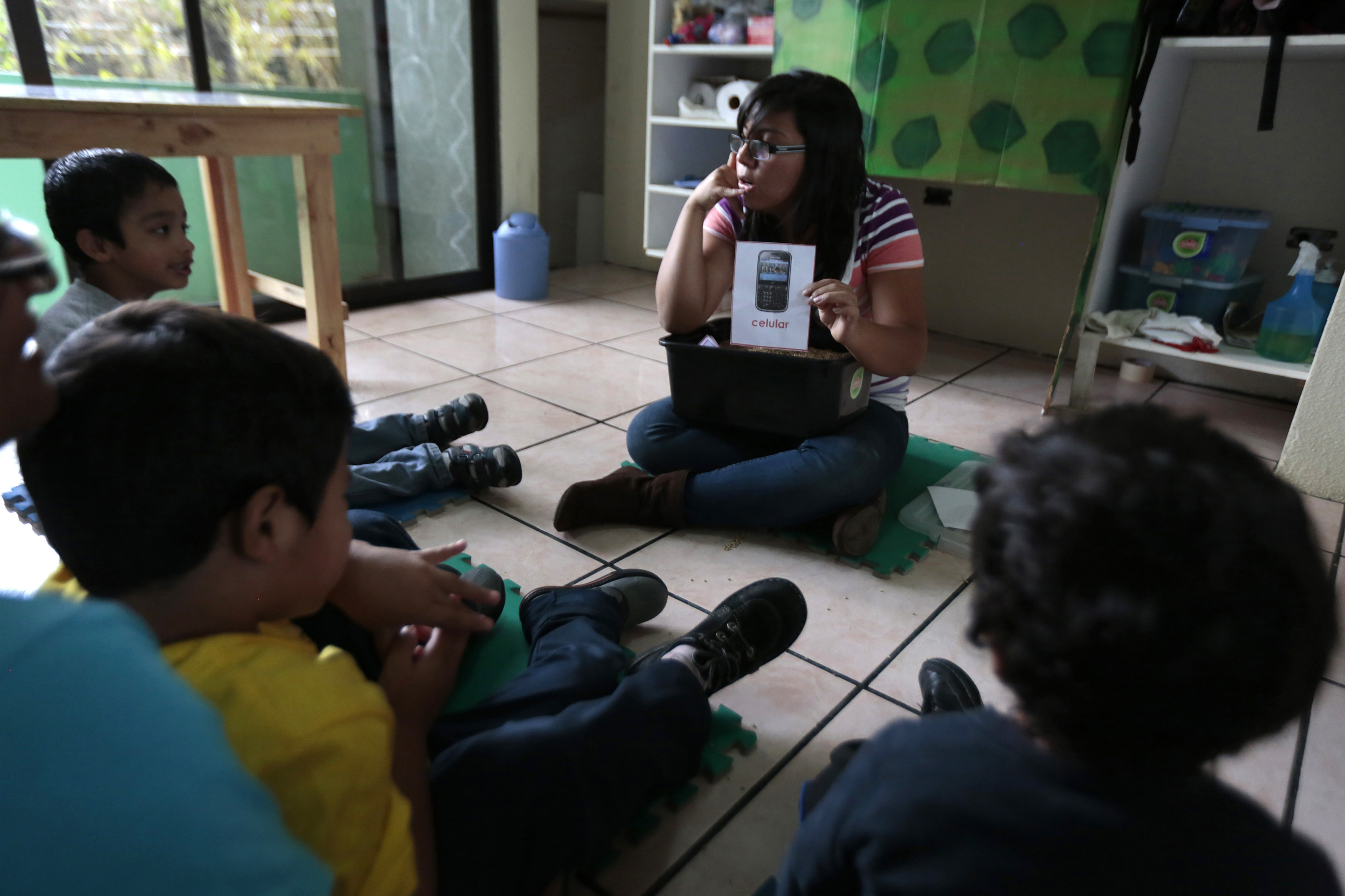 A teacher talks to children during a therapy class for autistic children in the Guatemalan Association for Autism, Guatemala City, March 13, 2014. (Reuters)
