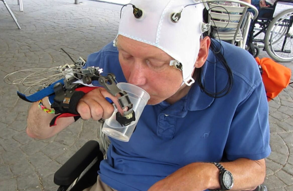 In this undated picture taken from video, a patient uses a robotic hand to drink from a cup, in Badalona, Spain. Scientists have developed a mind-controlled robotic hand that allows people with certain types of spinal injuries to perform everyday tasks. (AP)