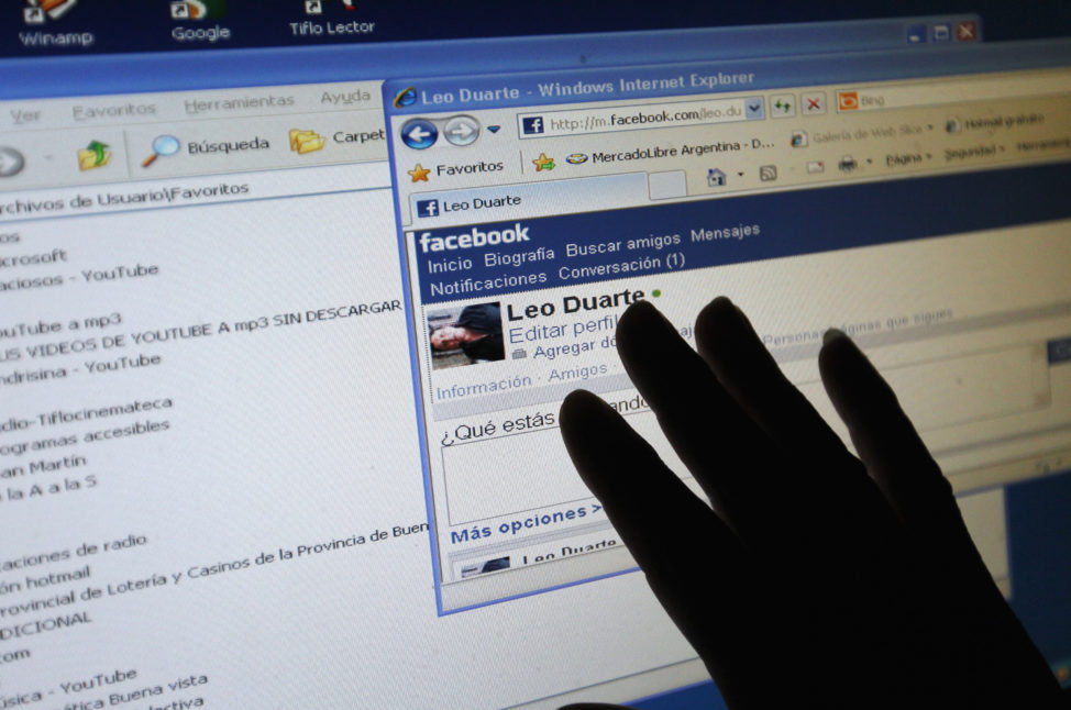 FILE - Leonardo Duarte, who lost his eyesight as a young adult victim of an attempted robbery, touches his computer screen as he listens to a special program that reads him messages and email from his Facebook page, at his home in Buenos Aires. (Reuters)