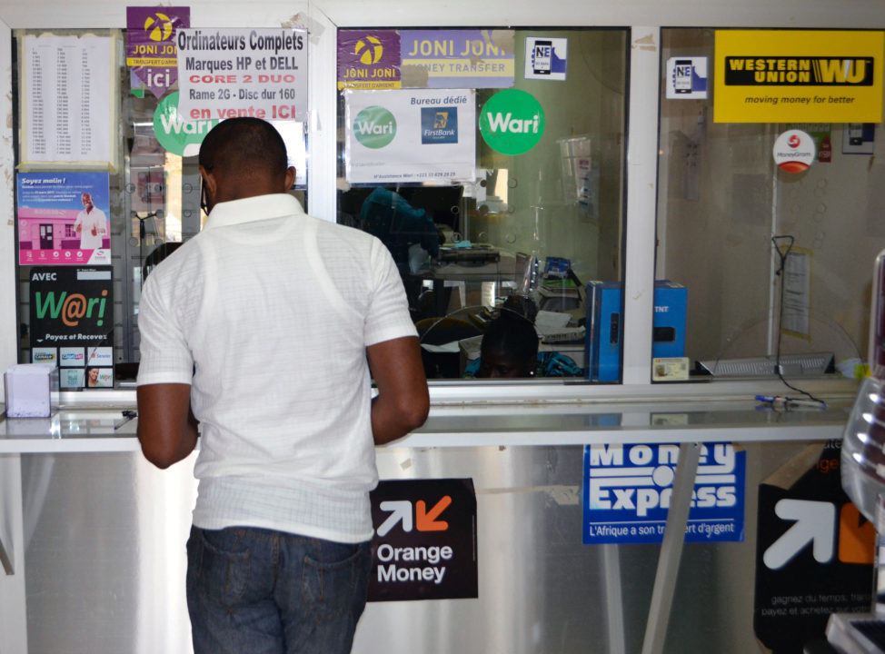 A customer makes a transaction at a money transfer point that offers services through Wari and other transfer companies in Dakar, Senegal, March 15, 2017. (Reuters)