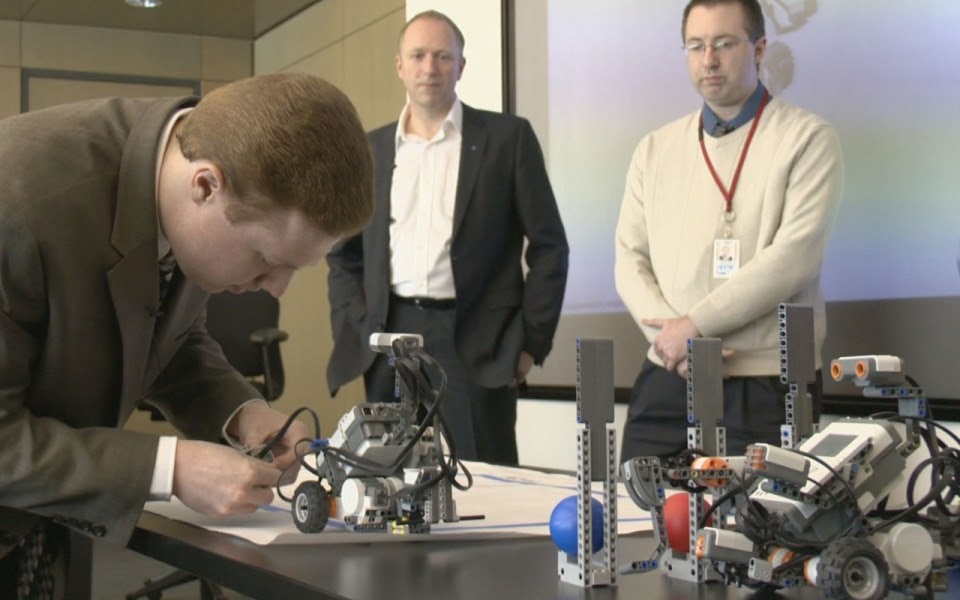 An employee demonstrates a Lego Mindstorm robot he built as part of the Autism at Work training curriculum intended to see how prospective employees problems. (SAP)