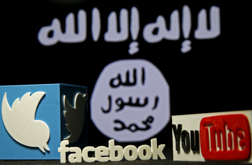 FILE - 3-D plastic representations of Twitter, Facebook and Youtube logos are seen in front of an IS flag in this photo illustration shot. (Reuters)