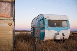 Things don’t look so prosperous, in this row at least, at a trailer park on the edge of the prairie.  (Charles Henry, Flickr Creative Commons)