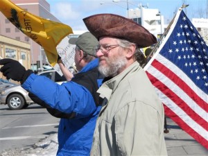The American Revolution gets its due at this rally in Anchorage, Alaska, with another flying of the “Don’t Tread on Me” flag and the wearing of an early tri-corner hat.  (AP Photo)
