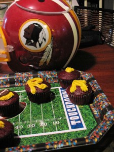 This Redskins helmet, with its Tuscan-red-colored warrior logo, is a centerpiece of this creative and tasty-looking display.  (littlerottenrobin, Flickr Creative Commons)