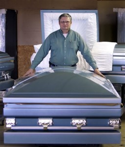 Keith Davis of the aptly named Goliath Casket Co. poses with one of its deluxe, extra-large models.  (AP Photo)
