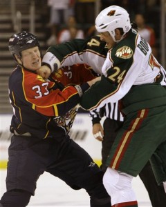 Wade Belak, left, absorbs a punch from Minnesota Wild enforcer Derek Boogaard, who, eerily, also died this summer.  Boogaard's death was ruled an accidental overdose of drugs and alcohol.  (AP Photo/Lynne Sladky)