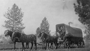 A family heads west in their Conestoga wagon that has all the conveniences!  Note the chimney.  (Library of Congress)