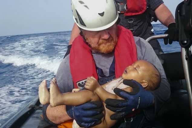 RECROP - In this Friday, May 27, 2016 photo, a Sea-Watch humanitarian organization crew member holds a drowned migrant baby, during a rescue operation off the coasts of Libya. Survivor accounts have pushed to more than 700 the number of migrants feared dead in Mediterranean Sea shipwrecks over three days in the past week, even as rescue ships saved thousands of others in daring operations. (Christian Buttner/EIKON NORD GMBH GERMANY via AP)