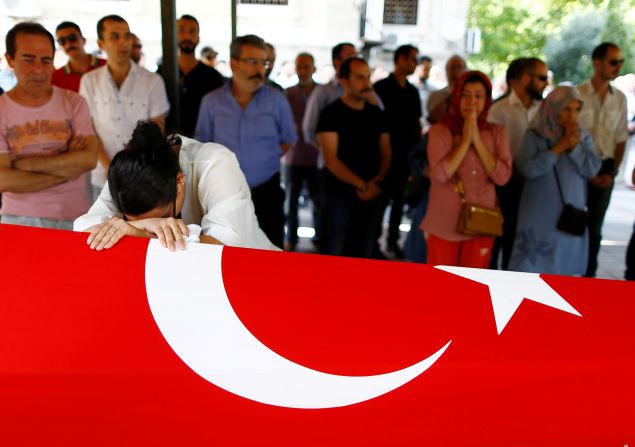 A relative of Gulsen Bahadir, a victim of Tuesday's attack on Ataturk airport, mourns at her flag-draped coffin during her funeral ceremony in Istanbul, Turkey, June 29, 2016. REUTERS/Osman Orsal - RTX2IVPI