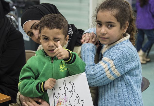 Two Syrian refugee children pose while their family undergoes medical screening before the beginning of an airlift to Canada, in Beirut, Lebanon December 9, 2015. The first plane load of Syrian refugees departed from Beirut on Thursday, aboard a military aircraft bound for Toronto. The Liberal government plans to resettle 10,000 refugees from Syria's four-year-old civil war by the end of the year and a further 15,000 by the end of February. Picture taken December 9, 2015.  REUTERS/Corporal Darcy Lefebvre/Canadian Forces Combat Camera/Handout via Reuters FOR EDITORIAL USE ONLY. NOT FOR SALE FOR MARKETING OR ADVERTISING CAMPAIGNS. THIS IMAGE HAS BEEN SUPPLIED BY A THIRD PARTY. IT IS DISTRIBUTED, EXACTLY AS RECEIVED BY REUTERS, AS A SERVICE TO CLIENTS - RTX1Y40I