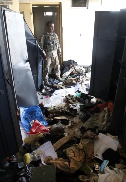 A member of the Afghan security forces stands in a government office, destroyed by Taliban fighters in Kunduz city, Afghanistan on Oct. 1, 2015. (AP)