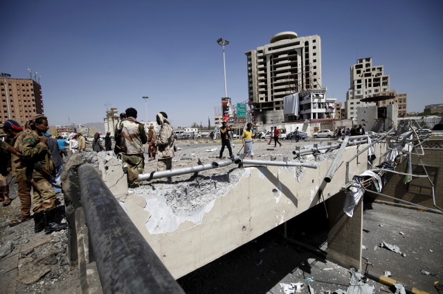 Houthi militants stand at the site of a Saudi-led air strike which targeted a tunnel leading to the presidential house near the Petrol Station in Yemen's capital Sanaa, October 1, 2015. (REUTERS)