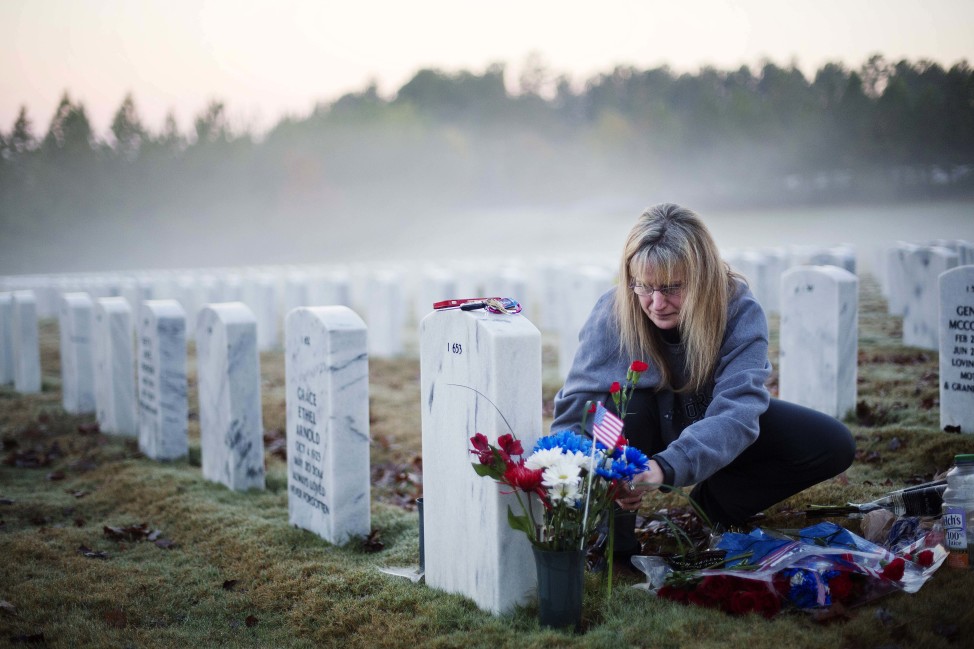 Jiffy Helton Sarver, of Monroe, Ga., places flowers at the grave of her son, 1st Lt. Joseph Helton, Jr., who was killed while serving in Iraq in 2009, at Georgia National Cemetery on Veterans Day, Nov. 11, 2015. (AP)