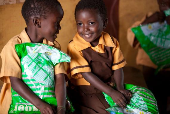 Students in Ghana hold insecticide-treated mosquito nets. (photo courtesy of PMI)