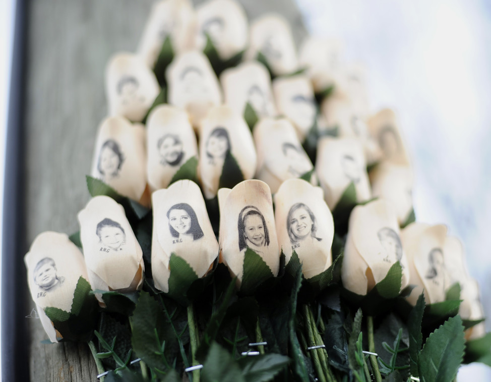 In this Jan. 14, 2013 file photo, white roses bearing the faces of victims of the Sandy Hook Elementary School shooting are displayed on a telephone pole near the school in Newtown, Conn. (AP)