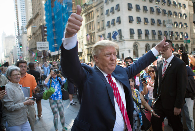 Republican presidential candidate Donald Trump waves to the crowd gathered in front of Trump Tower ahead of the arrival of the pope's motorcade for an appearance in New York's Central Park. September 24, 2015 (AP) 