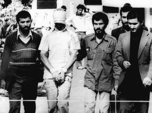 In this Nov. 9, 1979, file photo, a blindfolded  American hostage is paraded outside the U.S. embassy in Tehran.  