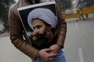 A Shi'ite Muslim man holds a picture of cleric Sheikh Nimr al-Nimr during a protest against the execution of Nimr, who was executed along with others in Saudi Arabia, in front of Saudi Arabia embassy in New Delhi on Jan. 4, 2016. (Reuters)