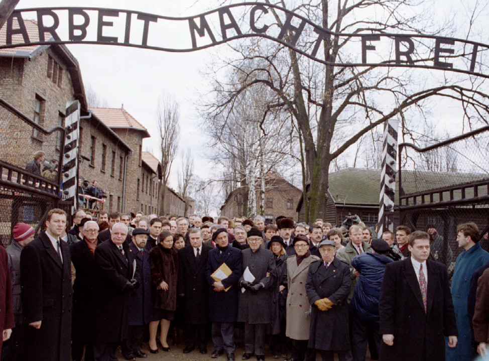 Officials and representatives mourn in silence at the main gate of the Auschwitz concentration camp to mark the 50th anniversary of its liberation on January 27, 1995. (Reuters) 