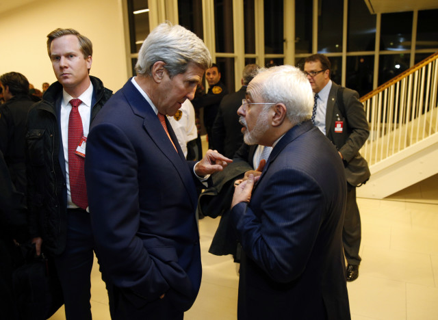 Secretary of State John Kerry talks with Iranian Foreign Minister Mohammad Javad Zarif, right, after the International Atomic Energy Agency verified that Iran has met all conditions under the nuclear deal on Jan 16, 2015 in Vienna. (AP)