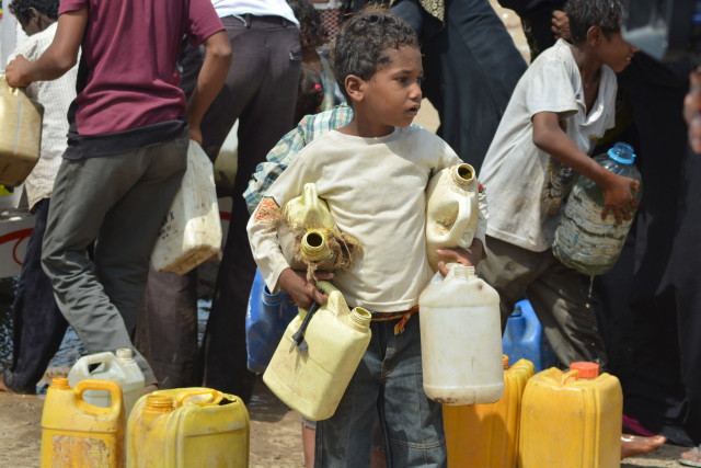 A boy carries jerry cans to fill from a water tanker truck in in Yemen's Red Sea city of Houdieda on Feb.15, 2016. (Reuters)