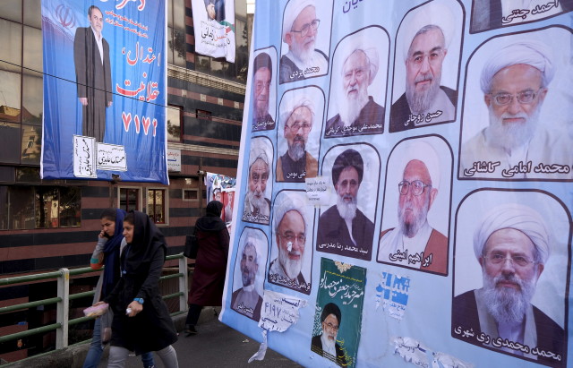 Women walk past electoral posters for the upcoming elections in central Tehran Feb. 24, 2016. REUTERS