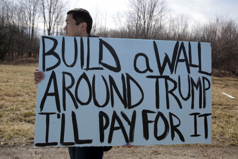 An anti-Trump protester holds his protest sign outside a rally for Republican presidential candidate Donald Trump in Cleveland, Ohio, March 12, 2016. (Reuters)