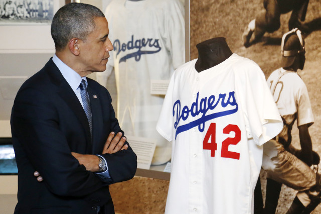 President Barack Obama looks at a Jackie Robinson jersey as he tours the National Baseball Hall of Fame in Cooperstown, New York, May 22, 2014. (Reuters)