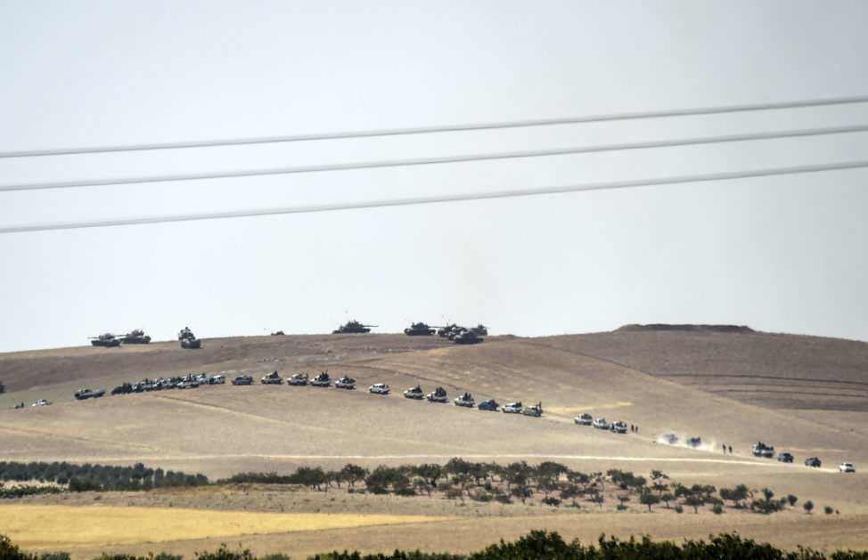 This picture taken from the Turkish Syrian border city of Karkamis in the southern region of Gaziantep, on August 24, 2016 shows Turkish army tanks and pro-Ankara Syrian opposition fighters moving two kilometres west from the Syrian Turkish border town of Jarabulus. (AFP) 