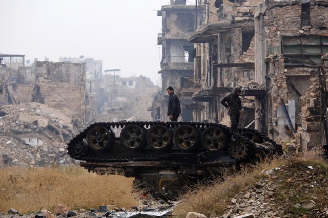 Forces loyal to Syria's President Bashar al-Assad stand atop a damaged tank near Umayyad mosque, in the government-controlled area of Aleppo, during a media tour, Syria December 13, 2016. (Reuters) 