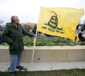 A tea party supporter holds a "Don't Tread On Me" flag during a rally at the Statehouse in Des Moines, Iowa in this AP file photo.