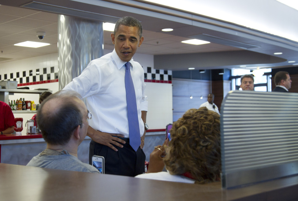 President Barack Obama greets people inside Sloopy's diner in the Ohio State Student Union, Tuesday, Aug. 21, 2012, in Columbus, Ohio. 