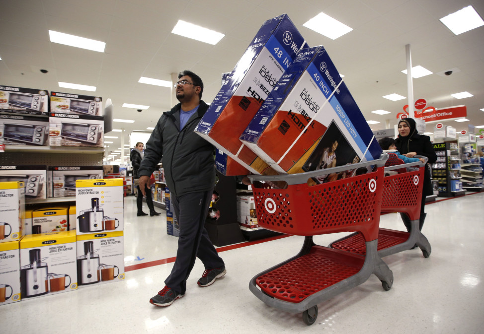 Ahmad Ali and his wife, Ghalzal, pick up three flat-screen televisions while shopping at a Target store just after midnight on Black Friday, Nov. 28, 2014, in South Portland, Maine. (AP Photo)