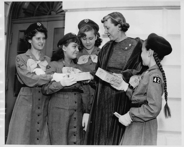 FILE - Troop 288 members Mamie and Ellen Moore present Girl Scout cookies to their aunt, first lady Mamie Eisenhower, at the White House in 1953. They’re joined by other scouts from the Washington, D.C., area. (Courtesy Girl Scouts of America)