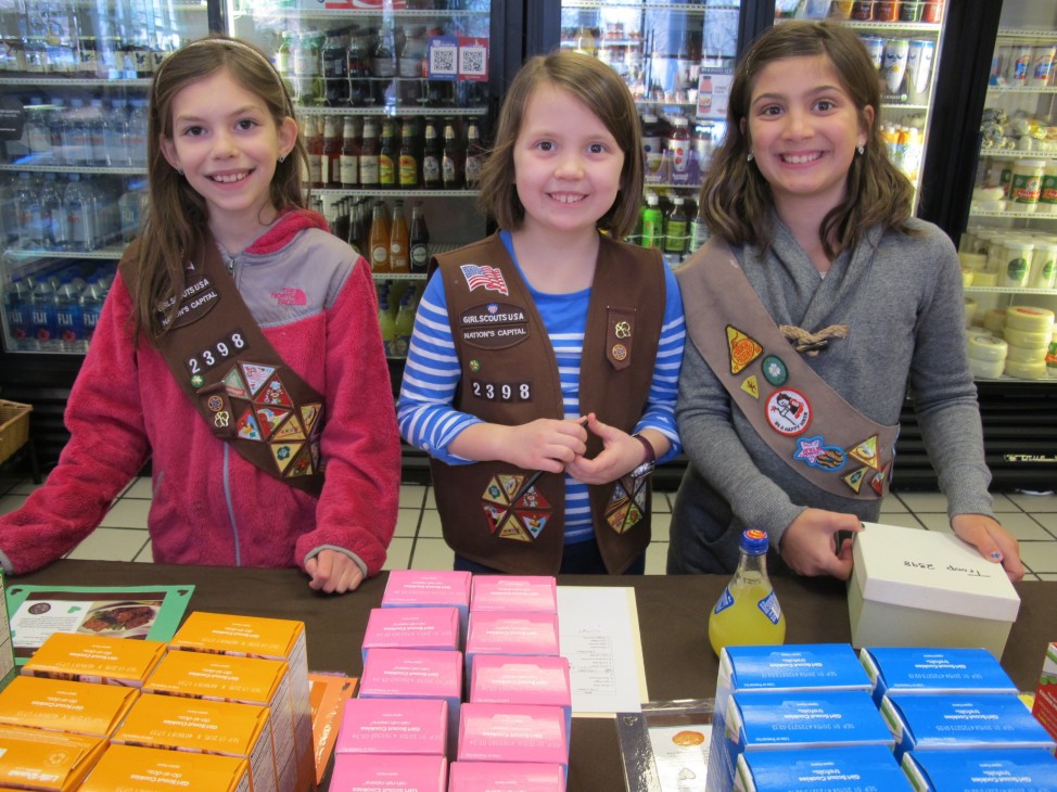From left, Girl Scout Troop 2398 members Sara Paget, Nora Nowicki and Olivia Shea peddle cookies at a retail shop in Arlington, Va., Feb. 22, 2015. (Carol Guensburg / VOA)