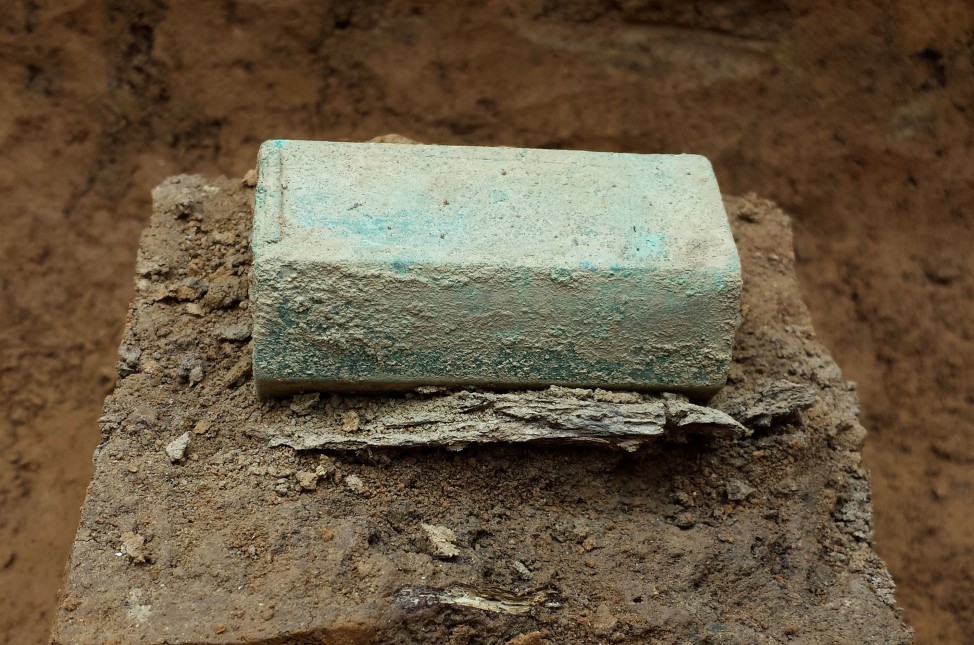 Silver Reliquary and fragments of coffin wood found in the grave of Capt. Gabriel Archer. (Courtesy of Jamestown Rediscovery Foundation, Preservation Virginia)