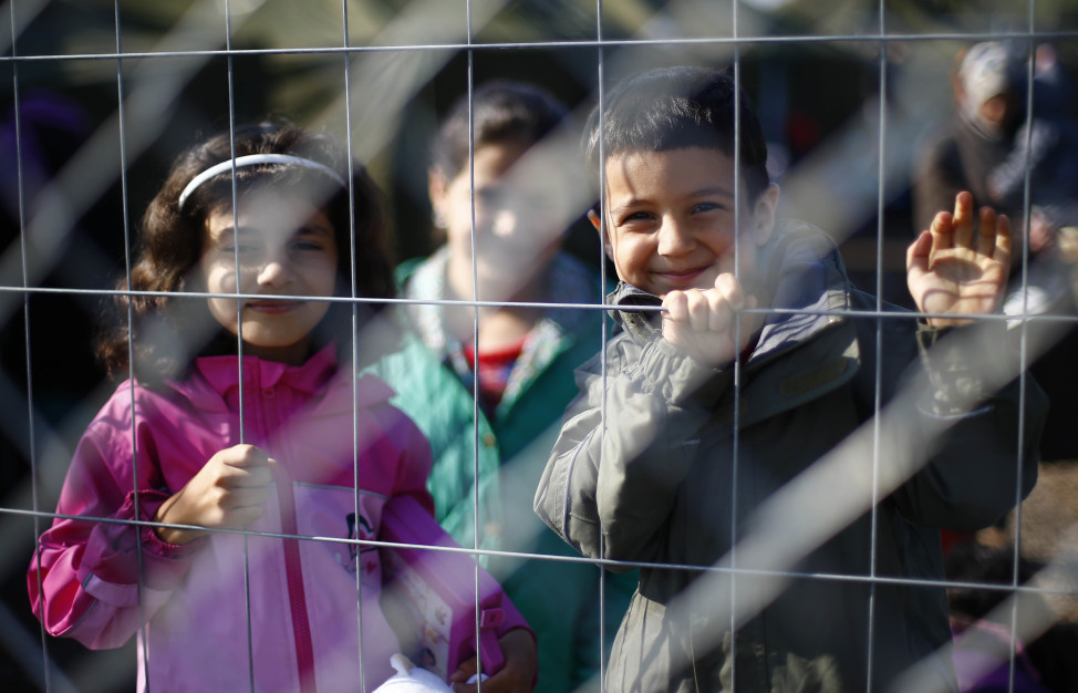 Children behind a fence in a temporary holding center for migrants near the border line between Serbia and Hungary in Roszke, southern Hungary in Roszke, Sept. 12, 2015. (AP Photo)