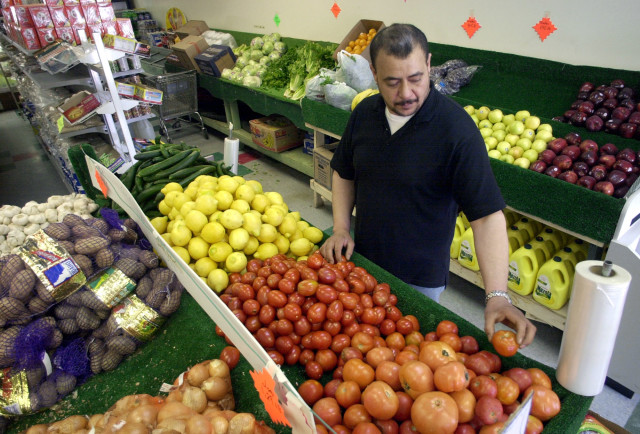 FILE -- Rae Alzaweny, owner of the Iraq Market grocery store, sorts produce in Dearborn, Michigan. (AP Photo)