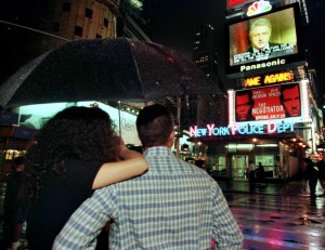 A couple watch US President Bill Clinton's image on a large screen TV in New York's Times Square as ..