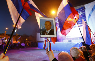 A woman holds a portrait of Russia's President Putin during celebrations on the main square of?the Crimean city of?Simferopol